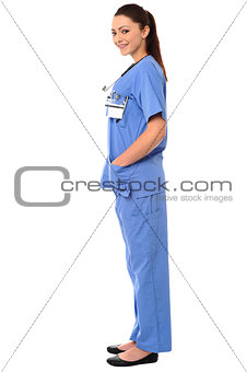 Title:Side pose of a young female doctor in uniform
