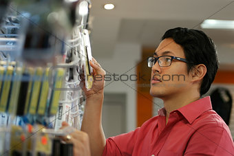Chinese Man Ordering Usb Drive On Shelf In Computer Shop