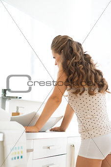 Frustrated young woman standing in bathroom