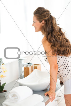 Happy young woman standing in bathroom