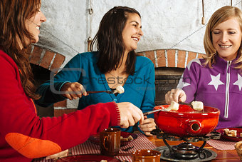 Three women having fondue dinner