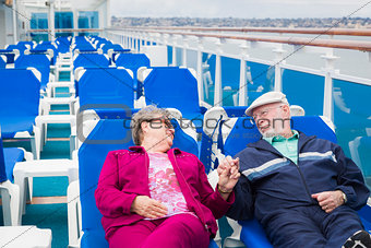 Senior Couple Relaxing On The Deck Of Cruise Ship