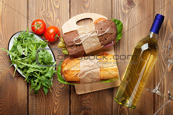 Two sandwiches, salad and white wine