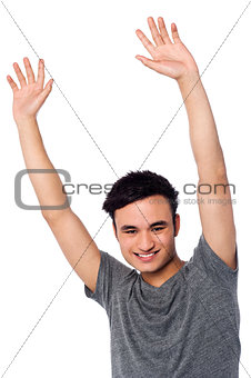 Cheerful young guy raising his arms