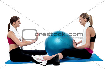 Fit women practicing an exercise with pilates ball