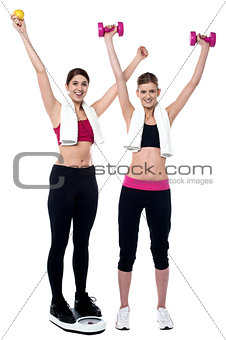 Two smiling girls working out together