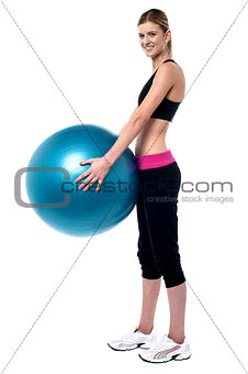 Female fitness trainer holding swiss ball