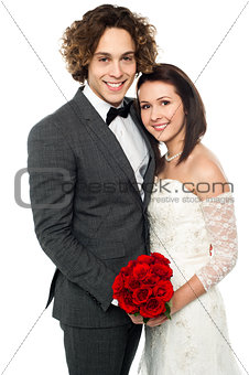 Affectionate wedding couple posing together