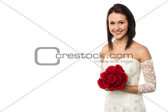 Pretty bride posing with love red roses bouquet