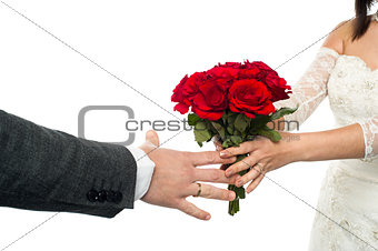 Bride offering rose bouquet to the groom