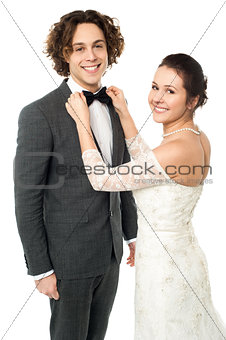 Pretty bride adjusting her man's bowtie