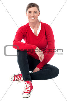 Pretty woman in casuals sitting on the floor