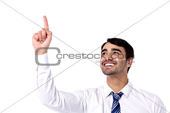 Happy businessman pointing upwards