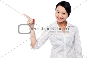 Happy young girl pointing at copy space area