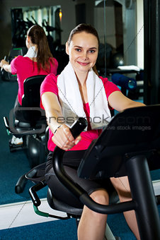 Cheerful woman doing cycling at fitness centre
