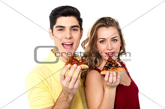 Couple posing with pizza slice