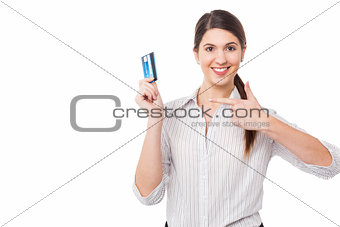 Smiling woman indicating towards credit card