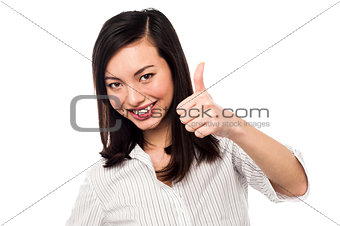 Smiling young woman showing thumbs up