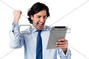 Excited businessman holding touch pad