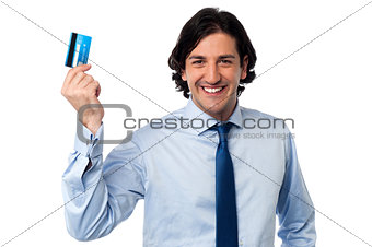 Businessman holding up his credit card