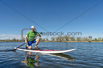 senior male on stand up paddleboard