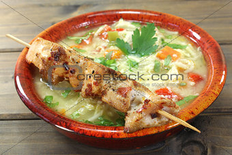Chicken soup with chicken skewers and noodles