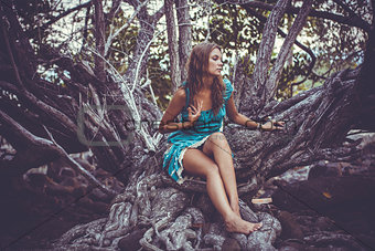 Portrait of beautiful elegant lady  with dress in a green jungle rainforest. Retro colors