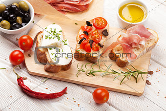 Bruschetta with cheese, tomatoes and prosciutto