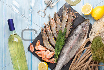 Fresh raw sea food with spices and white wine bottle