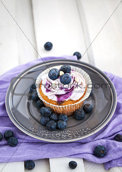 Tasty blueberry cupcake on plate