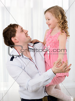 Father holding daughter and they dancing