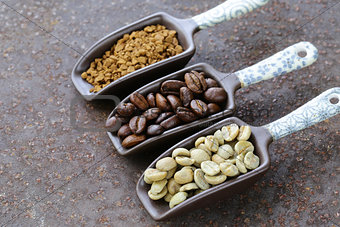 green, black coffee beans and ground in the scoop