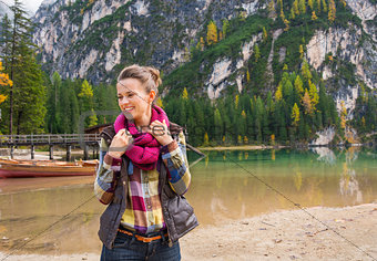 Portrait of smiling woman on Lake Bries readjusting scarf