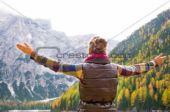 Woman hiker opening arms in joy against autumn background