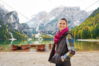 Woman on shores of Lake Bries with wooden boats in background