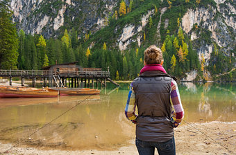 Woman hiker looking out at wooden boats and pier on Lake Bries
