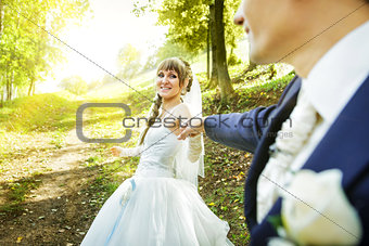 The bride is leading groom on a road