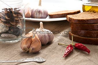 Close up still life of bread, garlic and pepper on linen cloth