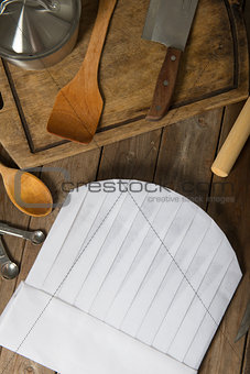 Chef hat and wooden spoons on wooden table