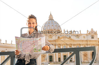 Smiling woman tourist in Vatican City in Rome reading a map