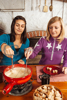 Two friends eating fondue