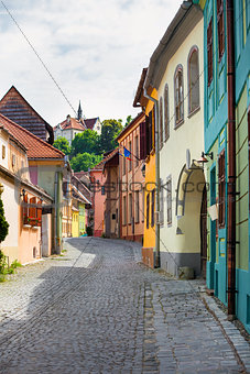 Stone paved old street with colored houses from Sighisoara fortr