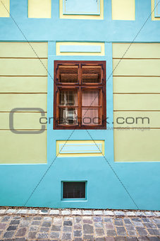 Blue house facade with wooden window from Sighisoara city old ce