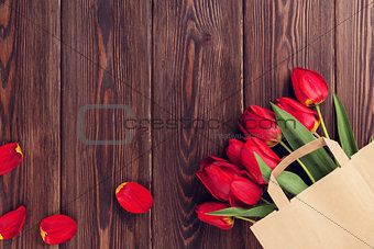 Red tulips bouquet in paper bag