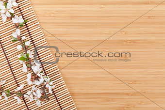 Sakura branch over bamboo mat