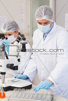 Scientists working attentively with microscopes