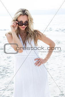 Smiling blonde in white dress wearing sun glasses