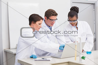 Concentrated scientists working together with laptop