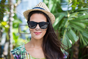 Smiling beautiful brunette wearing straw hat and sun glasses