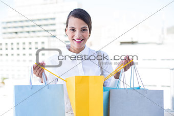 Happy woman looking inside shopping bags
